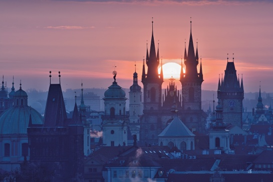 Praha, východ slunce nad pražskými věžemi