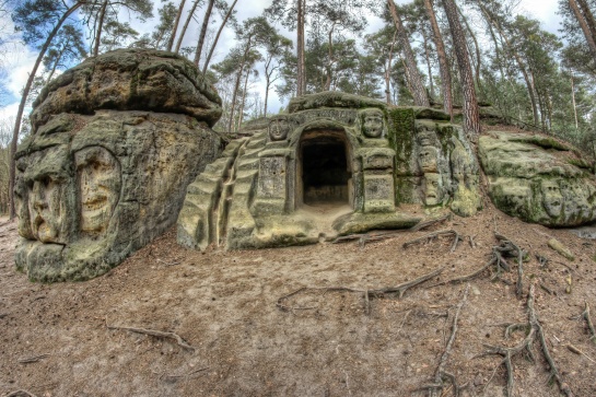 Skalní reliéfy bizarních hlav a umělá jeskyně Harfenice